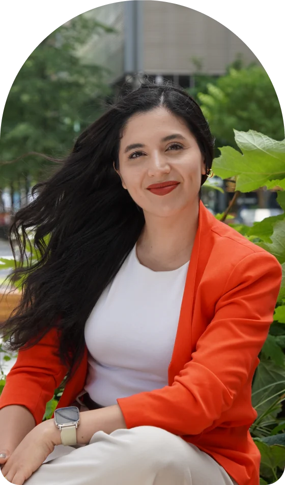 Portrait of Gaby outdoors in Berlin, smiling, wearing an orange blazer