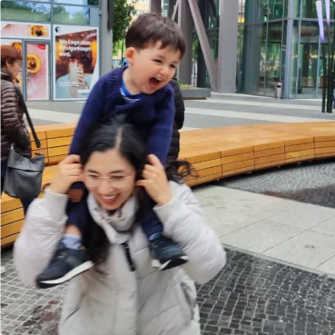 Gaby carrying her laughing son on her shoulders
