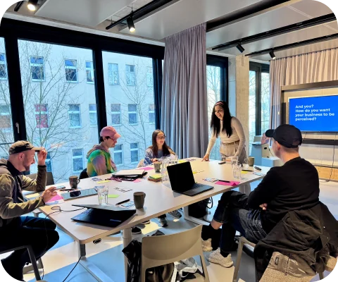 Gaby facilitating a workshop with a team around a large table